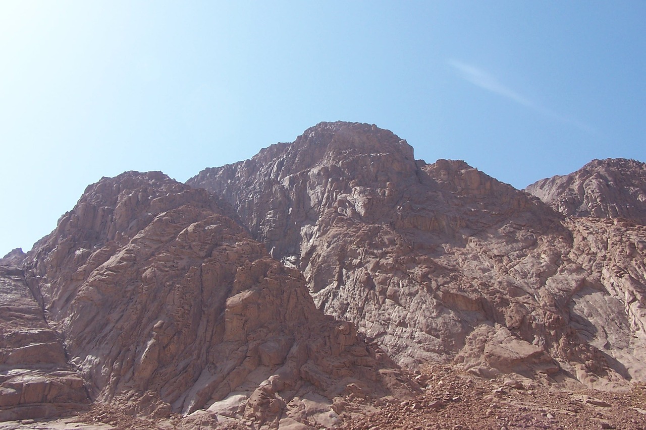 Rocky mountain with rugged terrain under a clear blue sky.