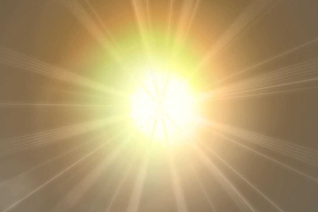 Bright yellow and orange sunburst with glowing rays radiating outward on a soft golden background.