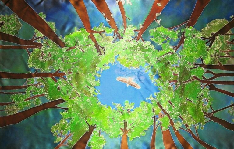 View from forest floor looking up at trees with green leaves; a bird soars in the blue sky above.