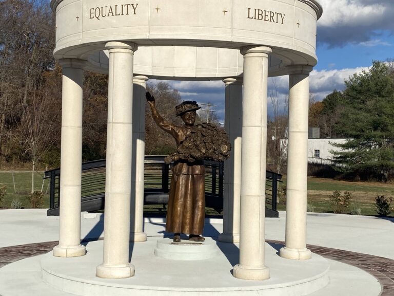 Bronze statue of a woman under a pavilion with the words Equality and Liberty inscribed above.