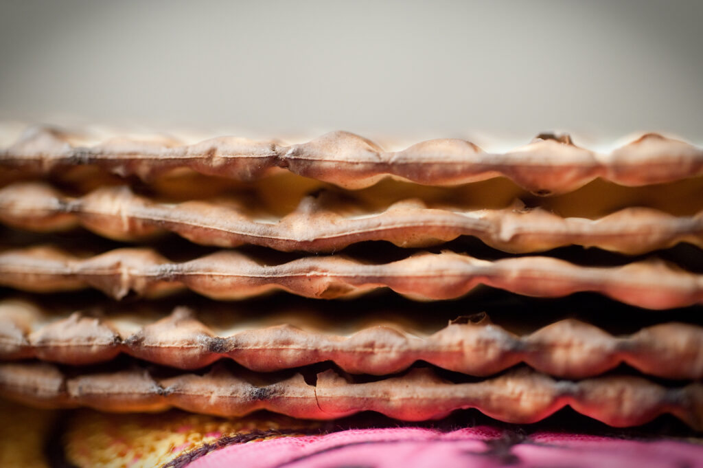 Close-up of a stack of matzo crackers with a blurred background.