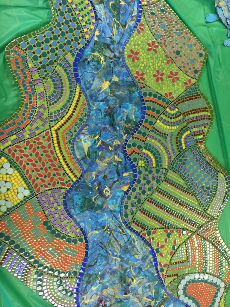 Colorful mosaic with a winding blue river, geometric patterns, flowers, and green, yellow, orange, and red tiles.