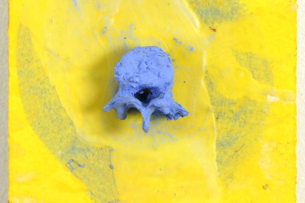 Abstract artwork: a blue skull-like sculpture on textured yellow canvas with blue brushstrokes.