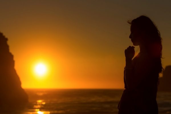 sundown, a woman prays