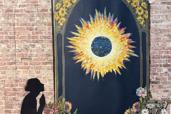 A silhouette kneels before a glowing sun within a floral arch against a brick wall, with flowers and a butterfly.