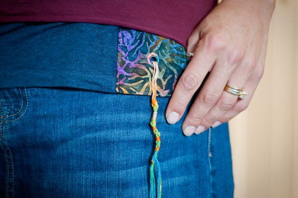 close up on rainbow colored tzitzit (fringes) on someone's waste