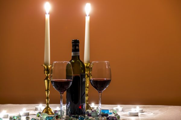 Shabbat candles and wine set on a white tablecloth