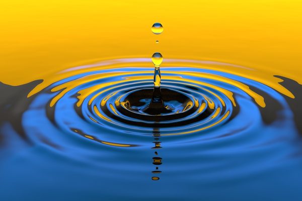 drops of water come down onto a surface of water, creating a circular ripple