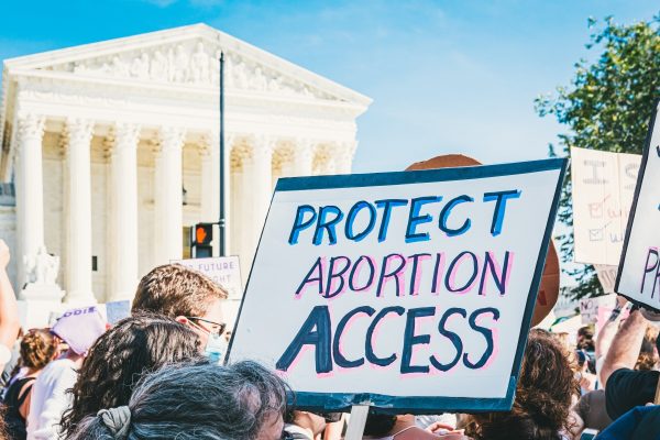 Protesters outside a government building hold signs advocating for abortion access.