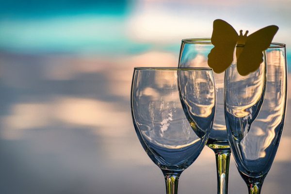 Three empty wine glasses with a yellow butterfly on one.