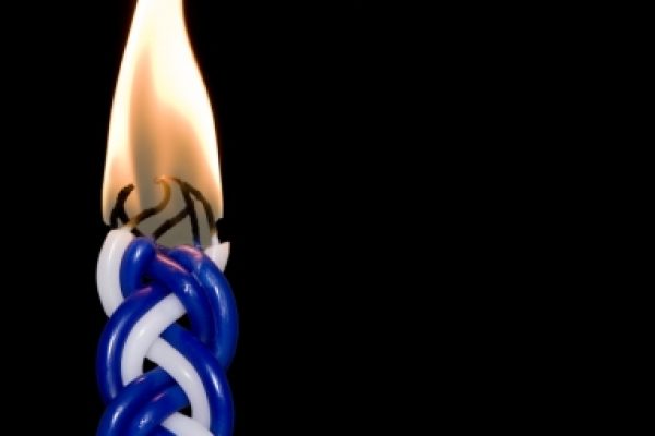 A lit, twisted blue and white candle against a black background.
