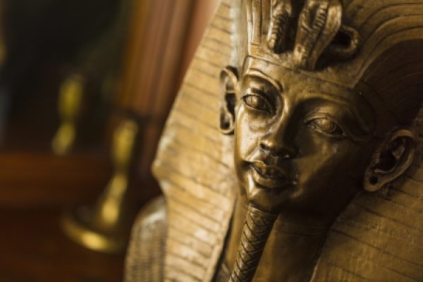 Close-up of an Egyptian pharaoh statue with intricate headdress and serene expression.