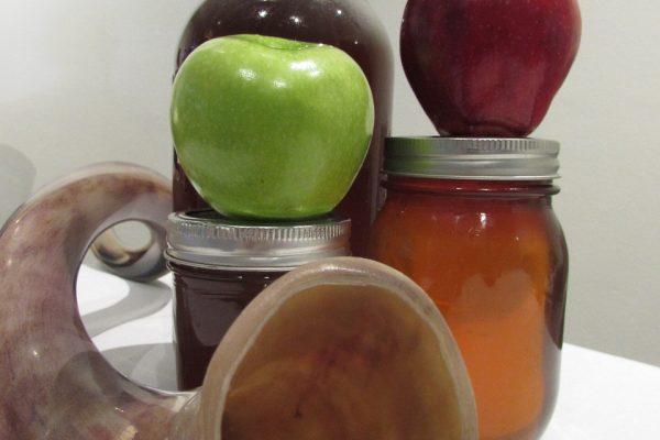 a shofar with jars of honey and apples