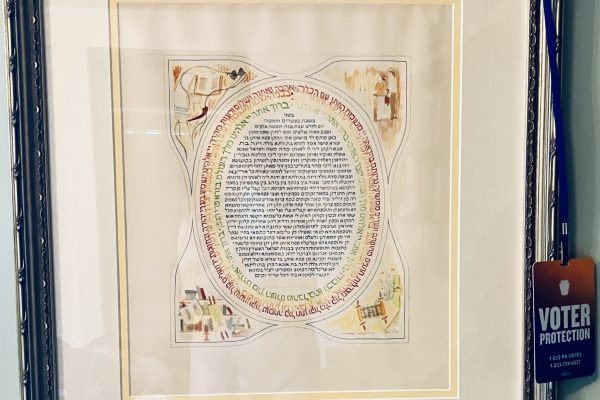 Framed artwork with intricate circular Hebrew text and small corner illustrations, next to a Voter Protection badge.
