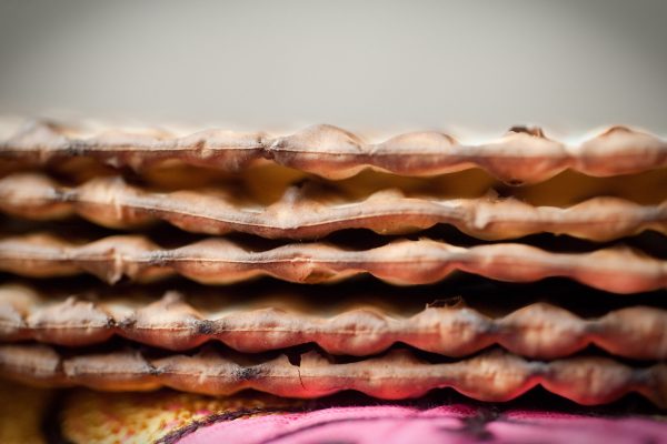 Close-up of a stack of matzo crackers with a blurred background.