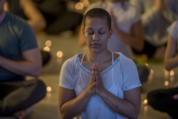 a woman meditating with candles