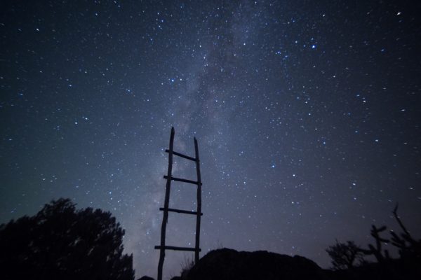 A wooden ladder silhouetted against a starry night sky and the Milky Way.