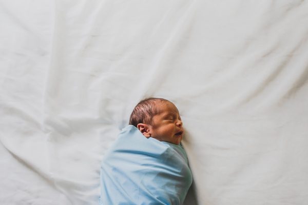 newborn baby wrapped in blue blanket