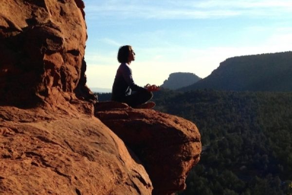 a person sits on a rock in the desert