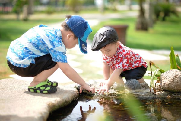 two children playing in a pond