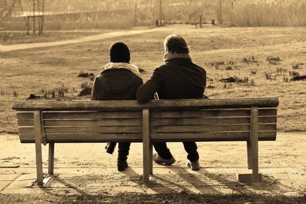 two people sitting on a bench