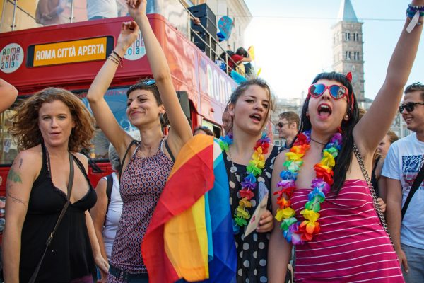 Rome, Italy - June 15, 2013: 2013 Gay Pride Parade in Rome, LGBT community parading in the centre of the city with flags, music and dance. Four girls sing and dance to music.