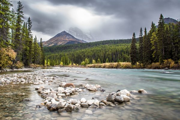 a river with rocks in it flows towards a mountain