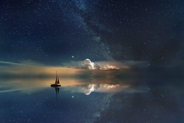 sailboat on the ocean with stars above