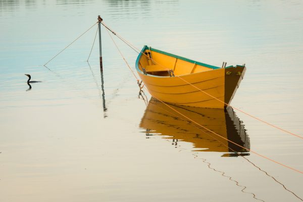 small yellow boat floating on water