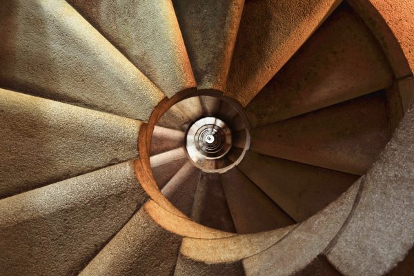 view from the top of a long beige spiral staircase