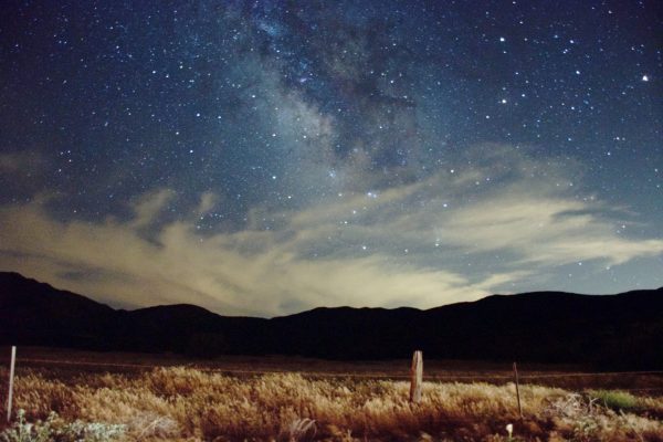 starry sky over desert and mountains