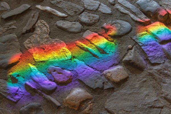 sun reflecting rainbow paint on stones