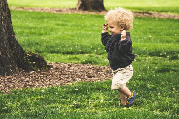 toddler boy with curly hair running
