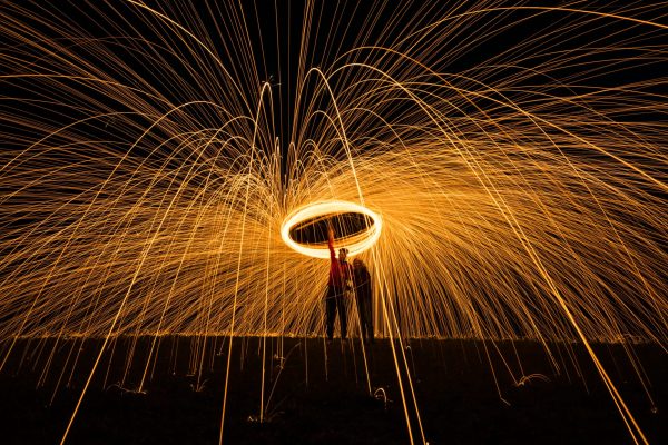 two people holding fire poi