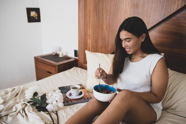 woman eating breakfast in bed