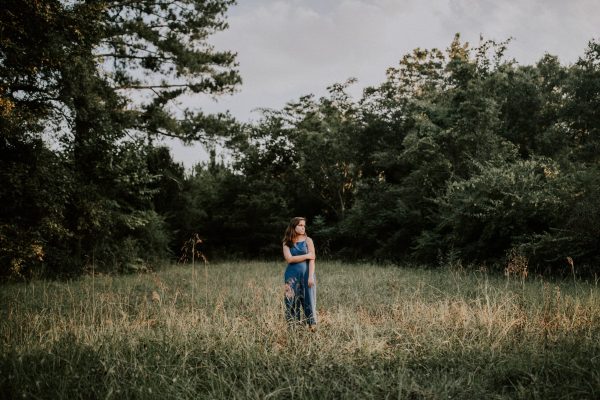 woman standing in a forest clearing